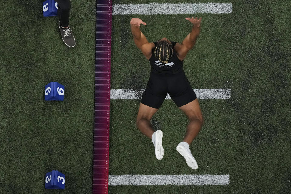 Washington wide receiver Rome Odunze participates in the broad jump during the NFL football scouting combine, Saturday, March 2, 2024, in Indianapolis. (AP Photo/Charlie Riedel)