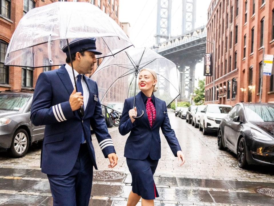 British Airways' new uniforms, pilot and FA walking in NYC with umbrellas.