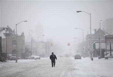 A man walks along a snow covered Cass Avenue in Detroit, Michigan January 2, 2014. REUTERS/Joshua Lott