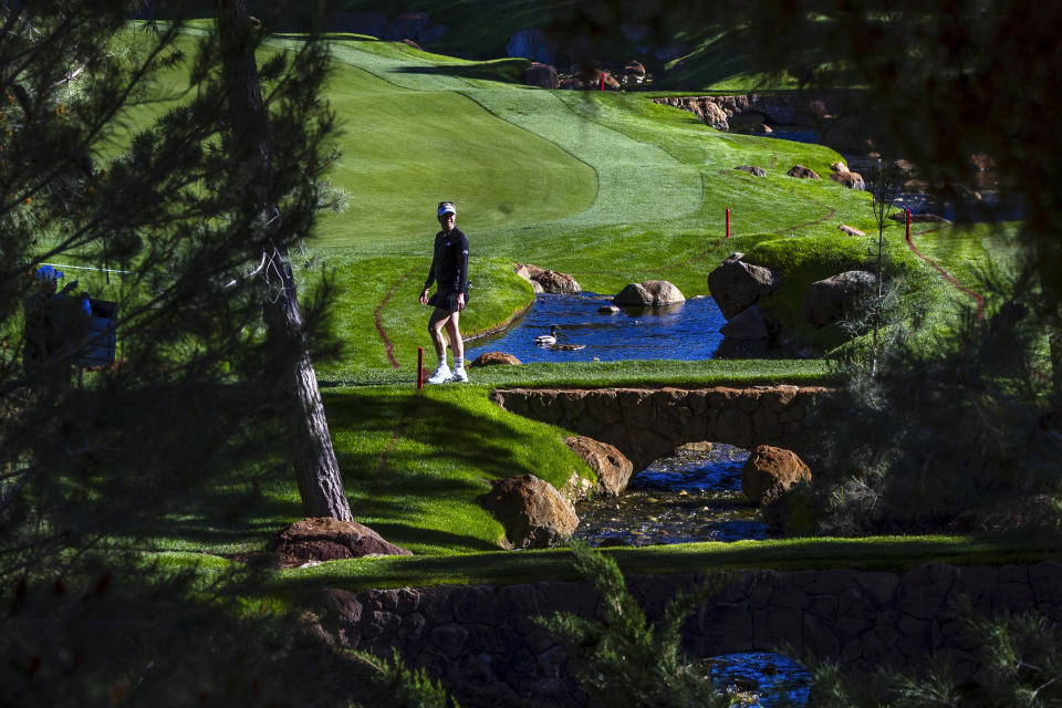 A woman walks across a foot bridge during the first day of the LPGA T-Mobile Match Play golf tournament at Shadow Creek on Wednesday, April 3, 2024, in North Las Vegas, Nev. (L.E. Baskow/Las Vegas Review-Journal via AP)