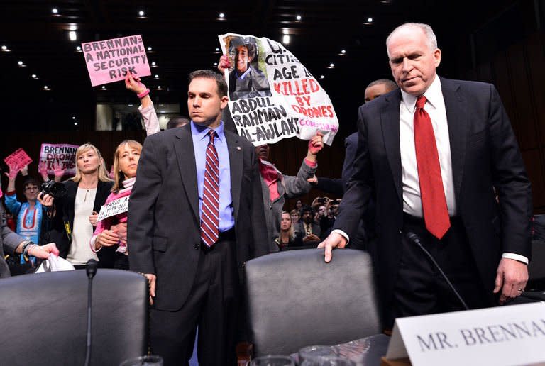 Anti-war protesters shout slogans as John Brennan (R), President Barack Obama's pick to lead the CIA, arrives to testify before a full committee hearing on his nomination to be director of the Central Intelligence Agency (CIA) in the Hart Senate Office Building in Washington, DC, on February 7, 2013