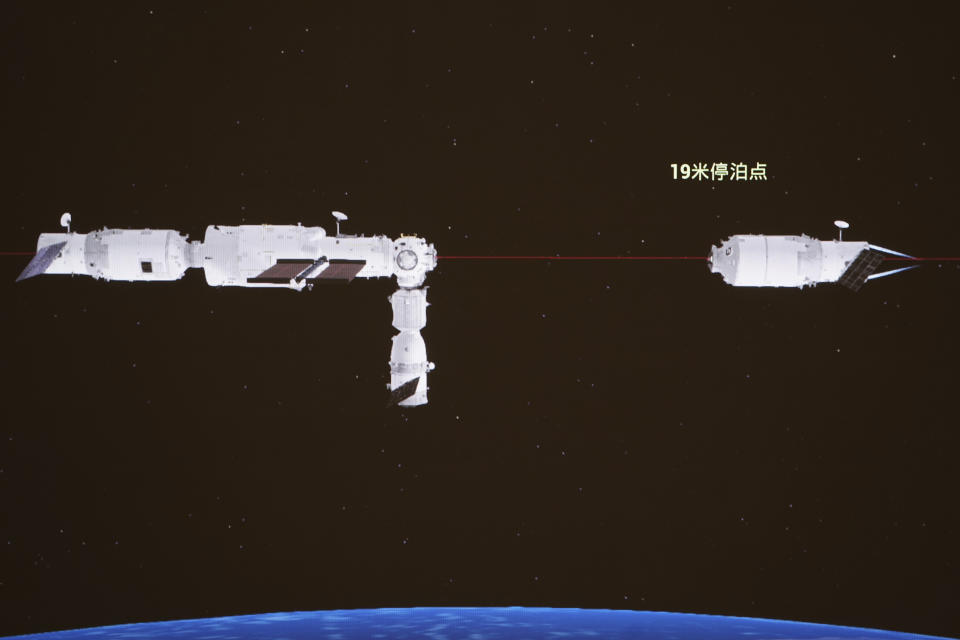 In this image released by Xinhua News Agency, a computer generated simulation screen image at the Beijing Aerospace Control Center on July 17, 2022, shows the Tianzhou-3 cargo craft, right, separating from the orbiting station combination. The Chinese cargo spacecraft has largely burned up on reentering the atmosphere, amid separate concerns over China's decision to allow a massive booster rocket to fall to Earth uncontrolled. Chinese characters on screen reads "19 meters parking point." (Guo Zhongzheng/Xinhua via AP)