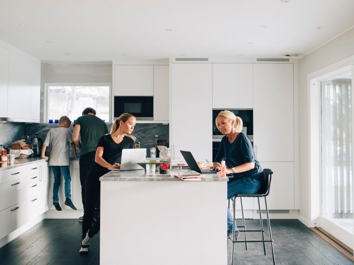 Family working on laptops in the kitchen