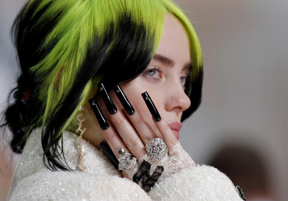 FILE - In this Sunday, Feb. 9, 2020 file photo Billie Eilish arrives at the Oscars at the Dolby Theatre in Los Angeles. Singer-songwriter Lewis Capaldi and rapper Dave lead the nominations for the U.K. music industry’s Brit Awards, set to be handed out Tuesday Feb. 18, 2020, at a ceremony in London. Quintuple Grammy winner Billie Eilish, 18, is set to give the first public performance of her James Bond theme song “No Time to Die.” (AP Photo/John Locher, File)