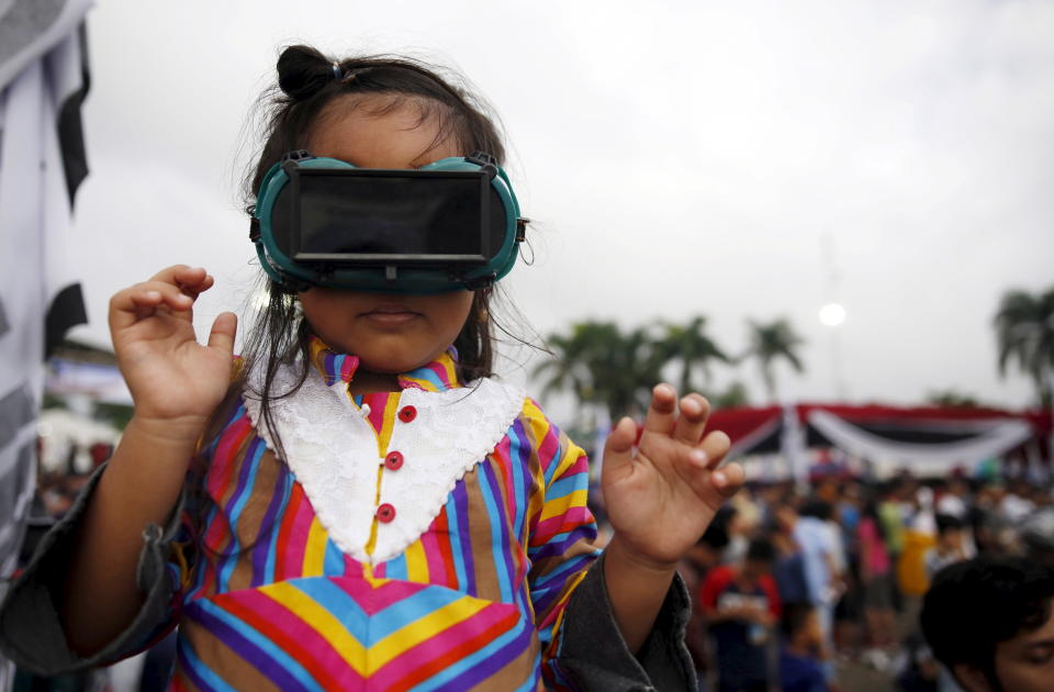 <p>A child wears goggles with a special filter over it during a solar eclipse in Palembang, South Sumatra province, Indonesia, March 9, 2016. (Photo: Darren Whiteside/Reuters) </p>