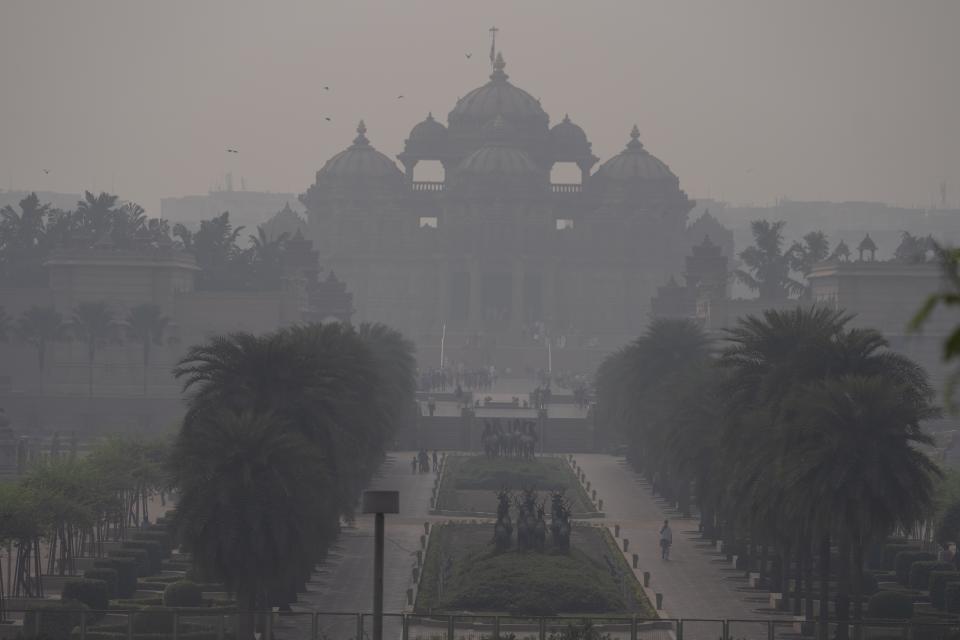 FILE - People visiting the Akshardham temple are visible through a thick smog in New Delhi, India, Wednesday, Nov. 8, 2023. Under certain wind directions, about 30% of Delhi's pollution can come from Punjab province in Pakistan. (AP Photo/Altaf Qadri, File)