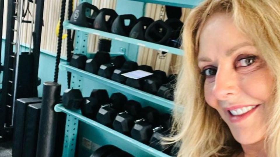 Carol Vorderman standing with weights