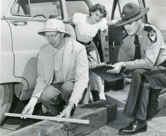 Carl Spessard measures the distance between the car and curb while Hudson High School senior Katherine Gill looks at the score on Ohio Patrolman James Hutson's clipboard during the driver training scholarship contest May 24, 1953, at Akron Municipal Airport.