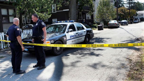 PHOTO: In this Sept. 13, 2011, file photo, police remain at an outpost on Harding Ave., in Waltham, Mass., after three men were found dead the previous day in the yellow house at center, behind the trash cans. (Joanne Rathe/The Boston Globe via AP)