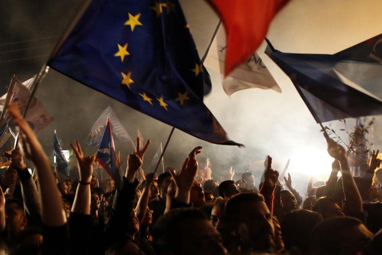 Supporters wave flags, including a European flag, as they listen to a speech by newly elected Turkish Cypriot leader Mustafa Akinci on April 26, 2015, in the northern part of Nicosia