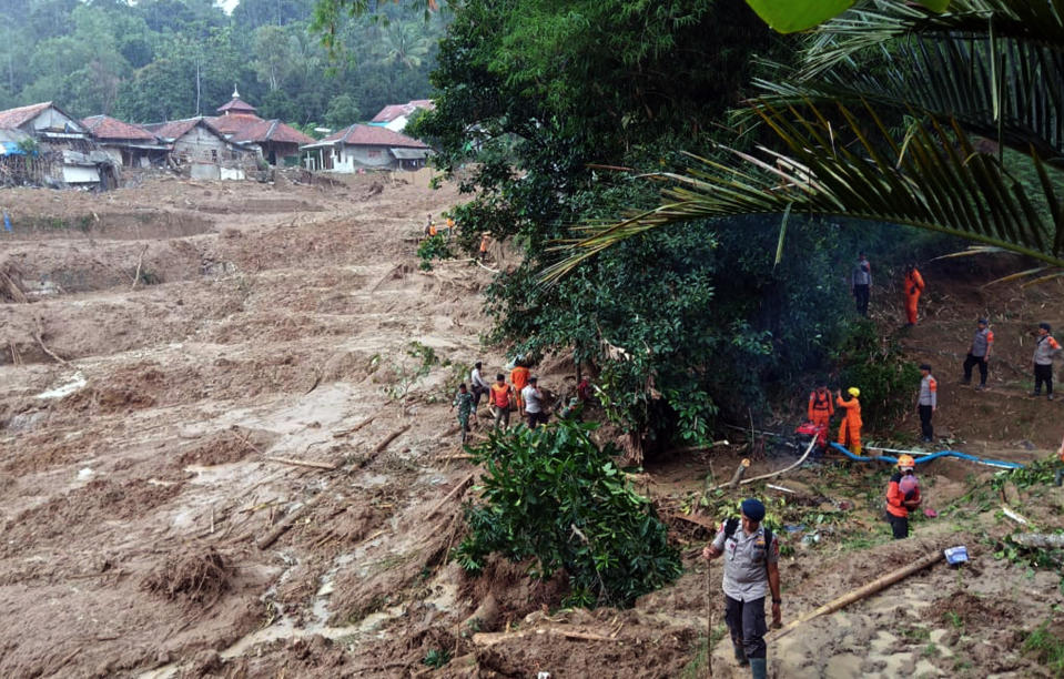 Rescuers search for victims at a village heavily affected by a landslide in Cigudeg, West Java, Indonesia, Friday, Jan. 3, 2020. Monsoon rains and rising rivers submerged hundreds of neighborhoods in greater Jakarta and caused landslides in the neighboring districts, which buried a number of people. (AP Photo/Kozer)