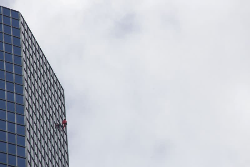 Foto del francés Alain Robert escalando el edificio de TotalEnergies en París