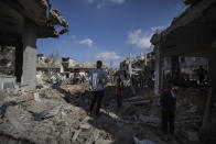 Palestinians inspect their destroyed houses following overnight Israeli airstrikes in town of Beit Hanoun, northern Gaza Strip, Friday, May 14, 2021. (AP Photo/Khalil Hamra)