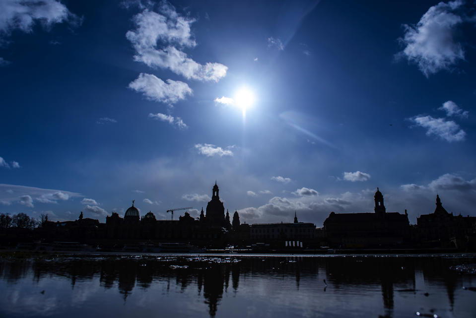 The sun shines behind Dresden's Old Town skyline with the Frauenkirche cathedral (Church of Our Lady), reflected in a puddle, in Dresden, Germany, Tuesday, Feb. 11, 2020 two days before the 75th anniversary of the Allied bombing of Dresden during WWII. British and U.S. bombers on Feb. 13-14, 1945 destroyed Dresden's centuries-old baroque city center. (AP Photo/Jens Meyer)