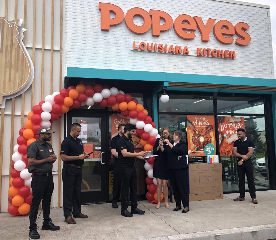 Ontario County Chamber of Commerce President and CEO Tracey Dello Stritto and Salvation Army Maj. Pamela Rhodes draw the name of a raffle winner at the grand-opening celebration of Popeyes Louisiana Kitchen in Canandaigua.