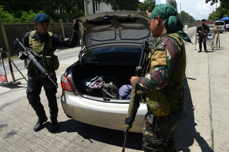 Philippine policemen check a car at a checkpoint in Iligan City, on the southern island of Mindanao, on May 24, 2017