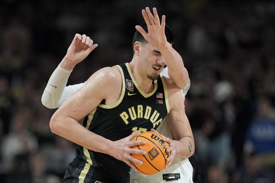 UConn center Donovan Clingan (32) fouls Purdue center Zach Edey (15) during the second half of the NCAA college Final Four championship basketball game, Monday, April 8, 2024, in Glendale, Ariz. (AP Photo/David J. Phillip)