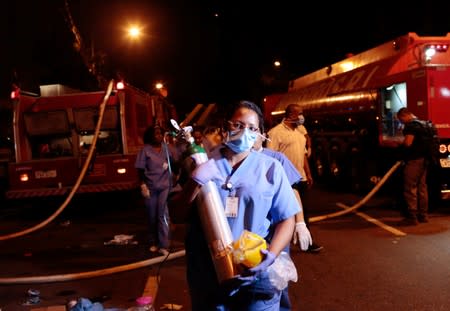 An employee is seen after a fire hit the Badim Hospital in Rio de Janeiro