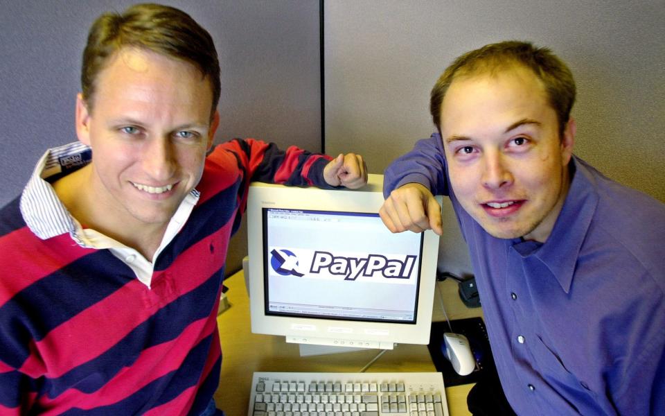 PayPal chief executive officer Peter Thiel and Elon Musk pose with the PayPal logo in 2000