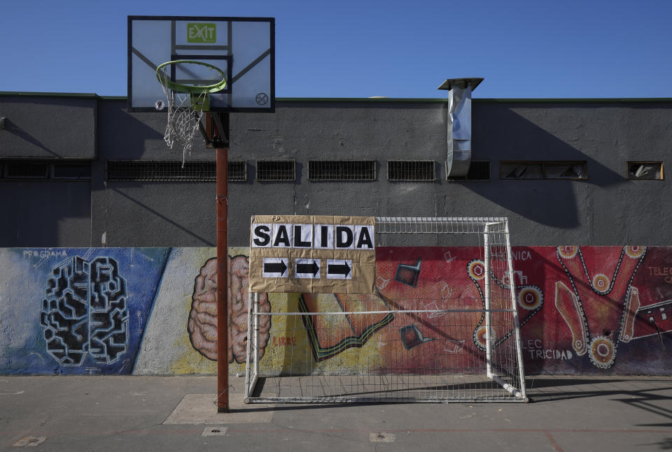 An exit sign hangs over a soccer net at a school will serve as a polling station for Sunday's general elections, including presidential, in Santiago, Chile, Friday, Nov. 19, 2021. (AP Photo/Esteban Felix)