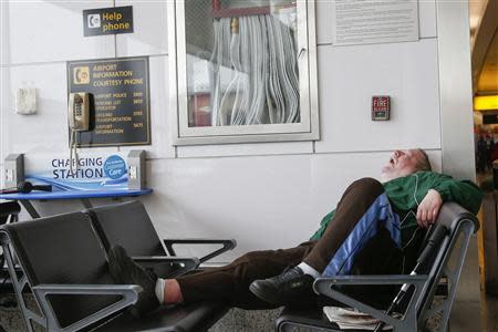 A man sleeps in a waiting area of the central terminal of LaGuardia Airport in the Queens borough of New York April 8, 2014. REUTERS/Shannon Stapleton