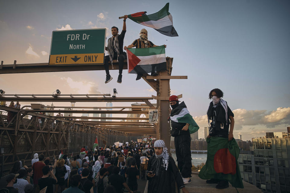 Protestors shout slogans as they cross Brooklyn Bridge during a Pro-Palestine demonstration demanding the cease fire on Saturday, Oct. 28, 2023, in New York. (AP Photo/Andres Kudacki)