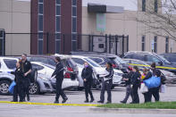 Law enforcement confer at the scene, Friday, April 16, 2021, in Indianapolis, where multiple people were shot at a FedEx Ground facility near the Indianapolis airport. (AP Photo/Michael Conroy)