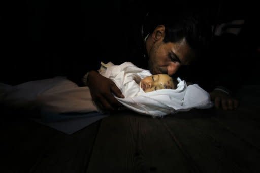 Palestinian relatives mourn over the body of Hanen Tafish, a 10-month-old girl, killed in an Israeli air strike in the Zeitun neighbourhood. Palestinian deaths from relentless Israeli air strikes has risen to 16