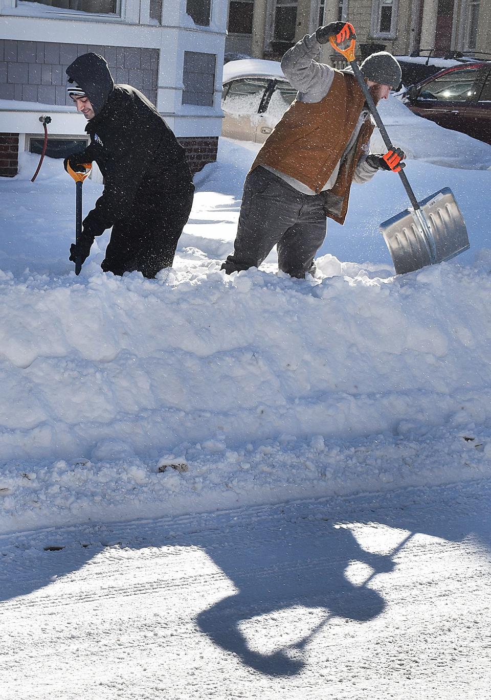 Ben Ramos and Patrick Connelly shovel on High street in Fall River.