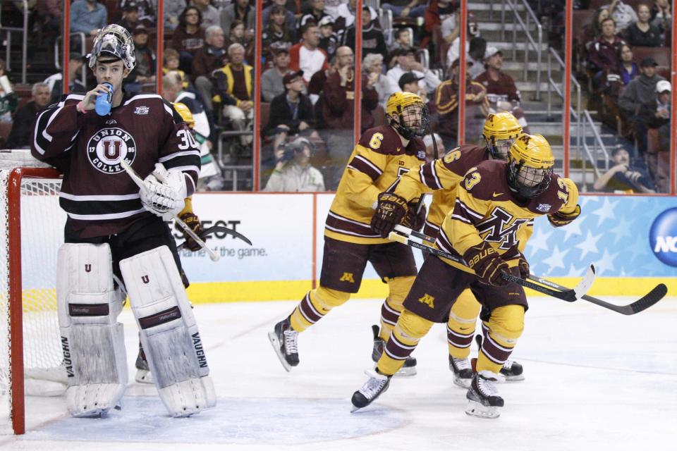 Minnesota's Taylor Cammarata, right, skates back with teammates after scoring a goal on Union's Colin Stevens, left, during the second period of an NCAA men's college hockey Frozen Four tournament game on Saturday, April 12, 2014, in Philadelphia. (AP Photo/Chris Szagola)