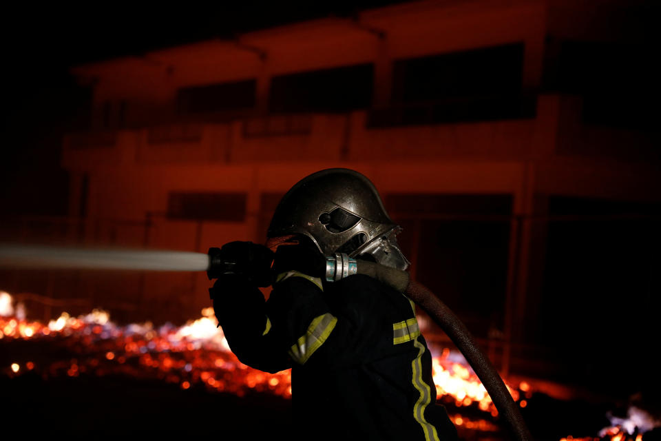 <p>A firefighter holds a hose as a wildfire burns at the village of Mati, near Athens, Greece, July 23, 2018. (Photo: Alkis Konstantinidis/Reuters) </p>