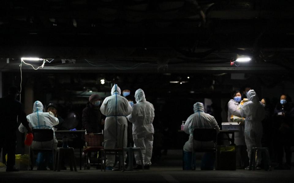 Residents undergo Covid-19 coronavirus tests at the basement of a residential compound as part of a mass testing programme following new cases of the virus emerging in Shijiazhuang, in central China's Hebei province - AFP