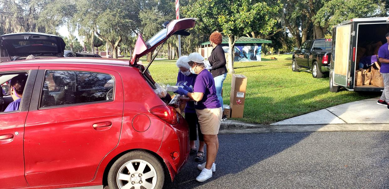 Volunteers place bread and a small box of pastries into the trunk of a Volusia County resident's car during one of the drive-thru food pantries put on by Backpack Buddies of Orange City. The nonprofit is hosting a drive-thru pantry in Orange City on Friday, Dec. 3, at 1365 Veterans Memorial Parkway.