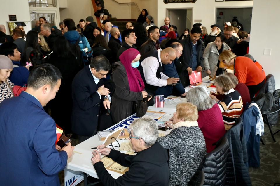 New U.S. citizens register to vote Monday, Jan. 22, 2024, with the help of members of the League of Women Voters of Greater Rockford after a naturalization ceremony in Rockford, Illinois.