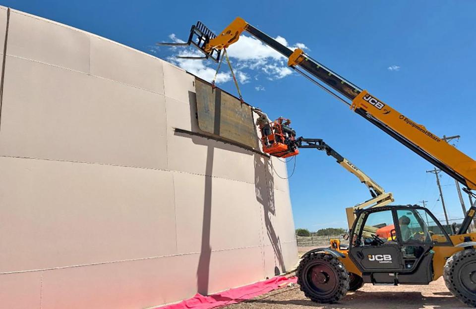 Construction workers with Tanco fit a replacement panel on a water tank in North Pueblo West. The tank started leaking in January following extreme cold weather.