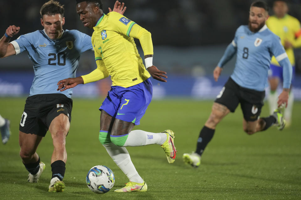 Brazil's Vinicius Junior, right, and Uruguay's Manuel Ugarte battle for the ball during a qualifying soccer match for the FIFA World Cup 2026 at Centenario stadium in Montevideo, Uruguay, Tuesday, Oct. 17, 2023. (AP Photo/Matilde Campodonico)