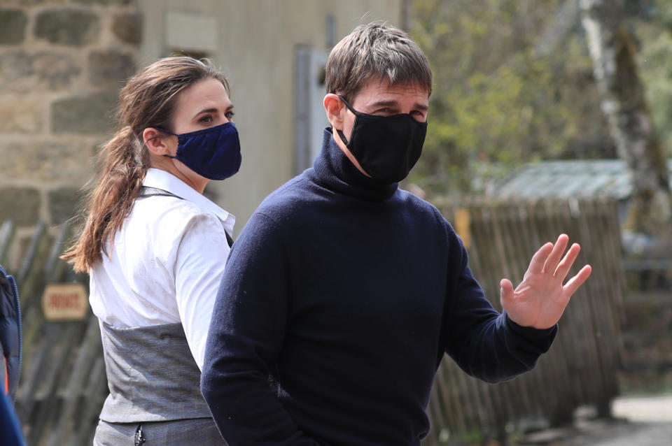 <p>Actor Tom Cruise waves to onlookers as he walks to the set of his latest project, which is filming in the sidings of the railway station in the village of Levisham in the North York Moors. Picture date: Tuesday April 20, 2021.</p>
