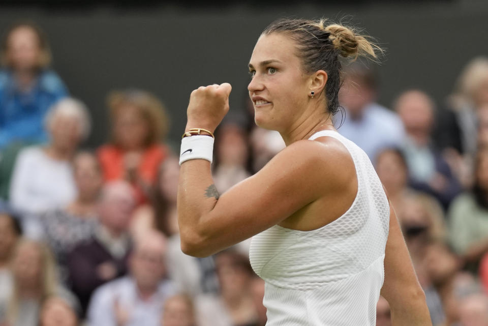 Aryna Sabalenka of Belarus celebrates a point during the women's singles quarterfinals match against Tunisia's Ons Jabeur on day eight of the Wimbledon Tennis Championships in London, Tuesday, July 6, 2021. (AP Photo/Kirsty Wigglesworth)