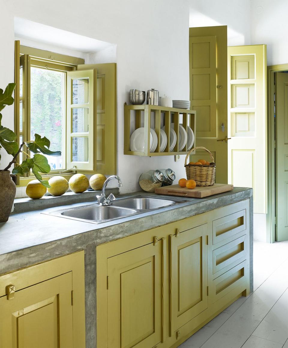 simple kitchen cabinets painted in a chartreuse color and matching window and door frames and white plank floor