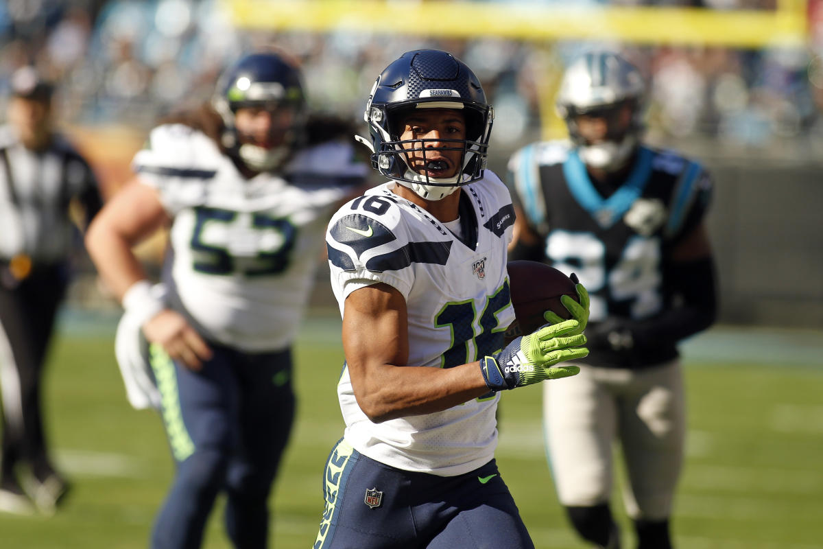 Seattle Seahawks wide receiver Tyler Lockett puts on his helmet as he walks  out to the field during the NFL football team's training camp Thursday,  July 27, 2023, in Renton, Wash. (AP