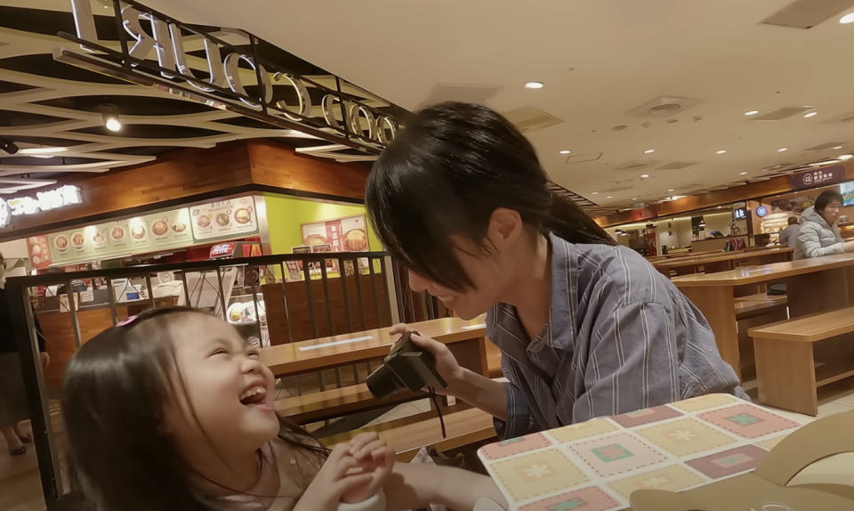 a mother and daughter laugh at a restaurant