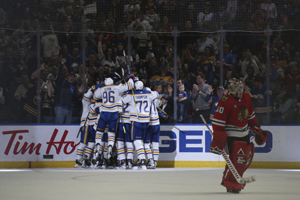 Chicago Blackhawks goaltender Collin Delia (60) skates off the ice as Buffalo Sabres players celebrate a goal by center Casey Mittelstadt during overtime in an NHL hockey game Friday, April 29, 2022, in Buffalo, N.Y. (AP Photo/Joshua Bessex)