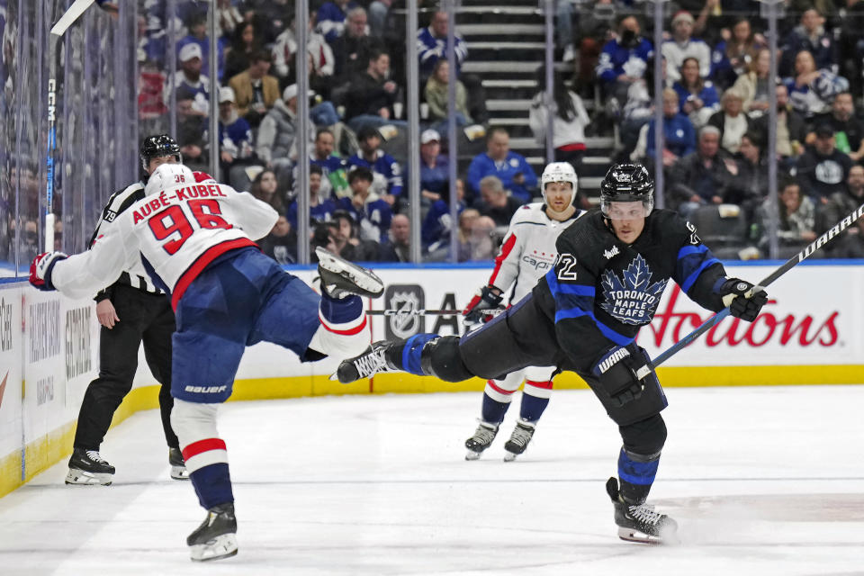 Washington Capitals forward Nicolas Aube-Kubel (96) and Toronto Maple Leafs defenseman Jake McCabe (22) collide during the first period of an NHL hockey game in Toronto, Thursday, March 28, 2024. (Nathan Denette/The Canadian Press via AP)