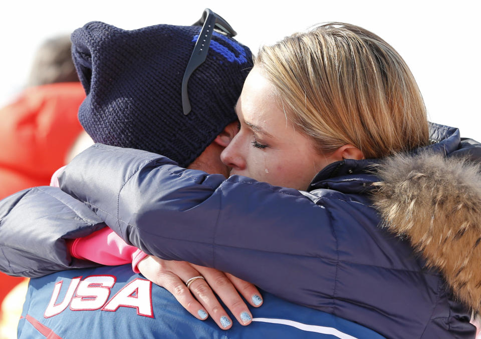 Morgan Miller hugs her husband, United States' Bode Miller after he took part in the flower ceremony for the men's super-G for his joint bronze medal at the Sochi 2014 Winter Olympics, Sunday, Feb. 16, 2014, in Krasnaya Polyana, Russia. (AP Photo/Gero Breloer)