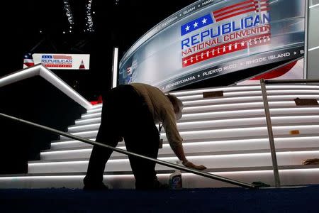 A worker cleans the stairs leading up to the main stage on the floor of the Republican National Convention in Cleveland, Ohio, U.S., July 16, 2016. REUTERS/Jonathan Ernst