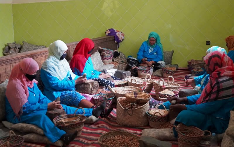 Mujeres amazigh se sientan juntan mientras muelen nueces de argán para extraer sus semillas, en Tiout, cerca de Tarudant