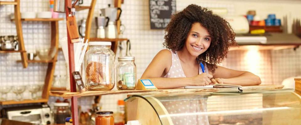 A young woman standing behind the counter in a coffee shop