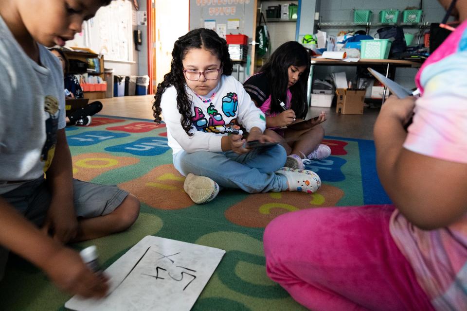 Ashley Soto, a third grader at Cora Kelly School in Alexandria, Va., observes as another student completes a math problem during after-school instruction.