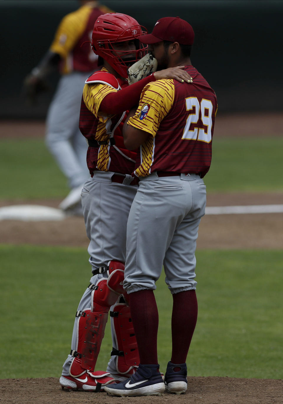 Venezuela catcher Robinson Chirinos, left, speaks with relief pitcher Harold Chirinos, during a final Olympic baseball qualifier game, in Puebla, Mexico, Saturday, June 26, 2021. (AP Photo/Fernando Llano)