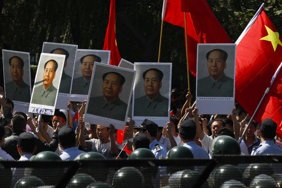 Anti-Japan protesters hold portraits of the late Communist leader Mao Zedong, one of them marked with hand-written characters which reads "People miss you," while marching on a street outside the Japanese Embassy in Beijing, China, Tuesday, Sept. 18, 2012. The 81st anniversary of a Japanese invasion brought a fresh wave of anti-Japan demonstrations in China on Tuesday, with thousands of protesters venting anger over the colonial past and a current dispute involving contested islands in the East China Sea. (AP Photo/Alexander F. Yuan)